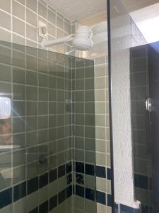 a bathroom with a shower with green and black tiles at condomínio Porto di Mare Casa 22 ALAGOAS in Paripueira +36 photos