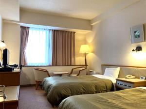 Postel nebo postele na pokoji v ubytování Miyajima Coral Hotel