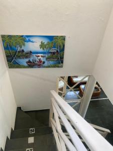 una pintura en la pared sobre una escalera en una casa en condomínio Porto di Mare Casa 22 ALAGOAS en Paripueira