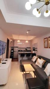 a living room with a couch and a table at The Mansion Kemayoran, lovely 3 bed apartment. in Jakarta