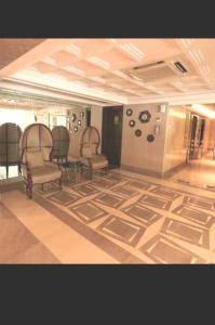 ジャカルタにあるThe Mansion Kemayoran, lovely 3 bed apartment.のリビングルーム(椅子2脚付)、ラグ付きの部屋