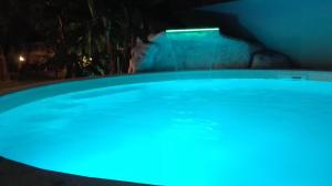 a blue pool at night with a person in the background at B&B Domus Aurea 20 in San Giovanni Teatino