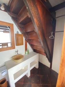 ein Badezimmer mit einem Waschbecken und einer Holzdecke in der Unterkunft The Hidden Escapes- Unique Tiny Home on Bingin Beach with Breathtaking Ocean & Sunset Views in Uluwatu