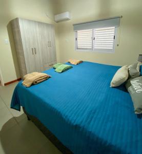 a bedroom with a large bed with blue sheets at Pinares del Norte in Federación