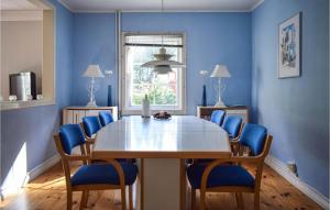 Ryd的住宿－4 Bedroom Gorgeous Home In Ryd，一间带桌子和蓝色椅子的用餐室