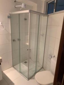 een glazen douche in een badkamer met een toilet bij Flat Beira Mar Carapibus in Conde