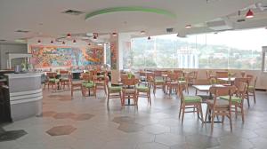 a restaurant with tables and chairs and a large window at MaxOneHotels at Jayapura in Jayapura