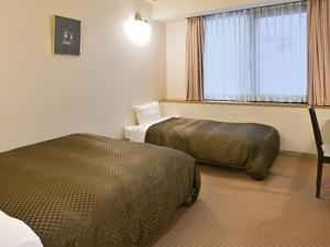 Postel nebo postele na pokoji v ubytování Miyajima Coral Hotel