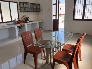 a glass table and four chairs in a kitchen at SUNNY Homestay Mui Ne in Phan Thiet