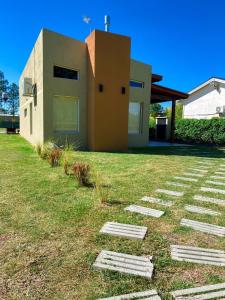 a house on a grassy field next to a building at Pinares del Norte in Federación