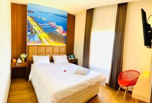 sypialnia z dużym białym łóżkiem i dużym obrazem w obiekcie The Bonte Hotel w mieście Puunggolaka