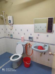 a bathroom with a toilet and a sink at PD Laguna Homestay Red in Port Dickson