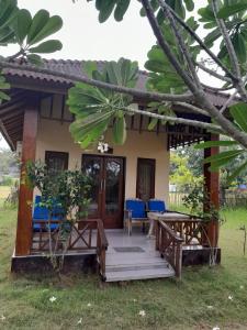 a house with a porch and blue chairs at Adinda Bungalows in Gili Air