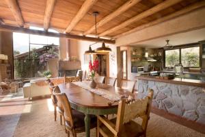 uma cozinha e sala de jantar com uma mesa de madeira e cadeiras em Luxury House at Sacred Valley Urubamba Cusco The Mountain Star em Urubamba