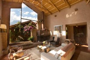 een woonkamer met een bank en een groot raam bij Luxury House at Sacred Valley Urubamba Cusco The Mountain Star in Urubamba
