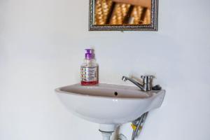 un lavabo blanco en un baño con una botella. en Diamond Beach Bungalow, en Nusa Penida