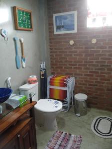a bathroom with a toilet and a brick wall at QUINTAS DA BARRA BNB a 30m da praia in Balneario Barra do Sul +173 photos