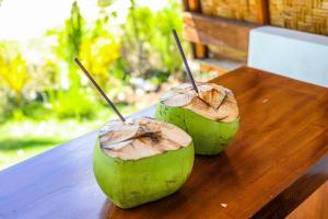 two halves of an avocado sitting on a wooden table at Diamond Beach Bungalow in Nusa Penida