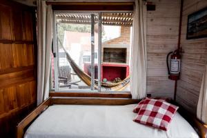 1 dormitorio con 1 cama y ventana con hamaca en Don Tito, en Aguas Dulces
