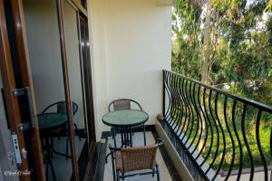 a balcony with a table and chairs and a window at Luxe Furnished Premium Unit in Meru