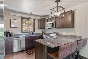 a kitchen with wooden cabinets and a large counter top at High Mountain Rustic Cabin Hot Tub Game Loft in Lead