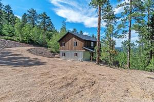 a house on the side of a dirt road at High Mountain Rustic Cabin Hot Tub Game Loft in Lead