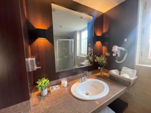 a bathroom with a sink and a large mirror at CASA MONTES PARDO in Cusco