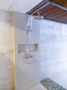 a shower with a shower head in a bathroom at Holiday Inn Resort Baruna Bali, an IHG Hotel - CHSE Certified in Kuta