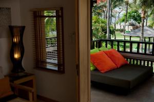 a porch with a bench with pillows on a balcony at Holiday Inn Resort Baruna Bali, an IHG Hotel - CHSE Certified in Kuta