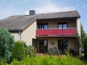 a house with a red balcony on top of it at Kellenhusen - Ferienhaus Espig 11 in Kellenhusen