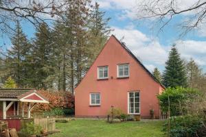 a red house with white windows in a yard at Mien Lütten in Husum