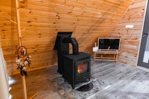 a wood stove in a room with a tv at SouL EsCaPe in Bălan
