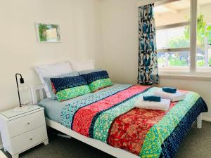 a bedroom with a bed with towels on it at Central Garden Guest House in Motueka