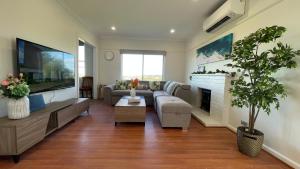a living room with a couch and a fireplace at Morwell Pet friendly 3 BRMS Rental home Free Wi-fi in Morwell