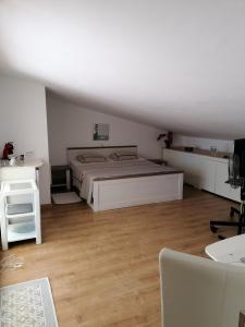 una camera da letto bianca con un letto e una scrivania di habitación con techo inclinado y vista al mar a Teulada