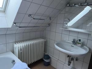 een badkamer met een wastafel, een spiegel en een radiator bij Poststübel in Hahnenklee-Bockswiese