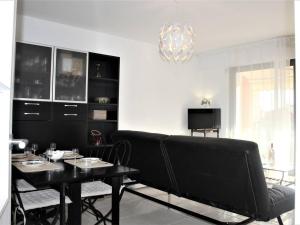 a living room with a black couch and a table at Appartement Villeneuve-Loubet, 3 pièces, 5 personnes - FR-1-252A-70 in Villeneuve-Loubet