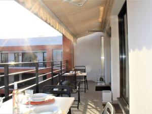 a balcony with tables and chairs on a building at Appartement Villeneuve-Loubet, 3 pièces, 5 personnes - FR-1-252A-70 in Villeneuve-Loubet