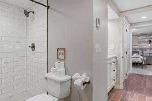 a white bathroom with a toilet and a shower at Roomy 5 Bed 3 Bath Fire Place Large Outdoor Space in Rapid City +28 photos
