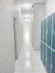 a hallway with blue lockers and a white corridor at Stay Hub in Timuran