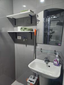 a white bathroom with a sink and a mirror at air residences in Manila