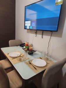 una mesa con dos platos y una TV en la pared en air residences en Manila