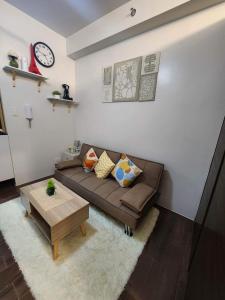 air residences في مانيلا: غرفة معيشة مع أريكة بنية وطاولة