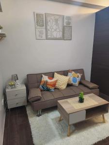 a living room with a brown couch and a table at air residences in Manila