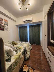 1 dormitorio con 2 camas y ventana en air residences en Manila