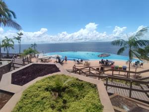 uma grande piscina com o oceano ao fundo em Tropical Executive Vista Ponta Negra em Manaus