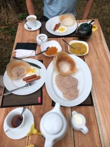una mesa de madera con platos de desayuno. en ohm lagoon home, en Tangalle