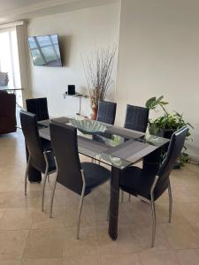 a dining table and chairs in a room at Playa Bonita Rosarito in Rosarito