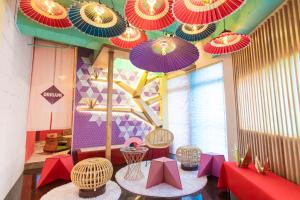 a room with colorful umbrellas hanging from the ceiling at Moshi Moshi Rooms in Tokyo