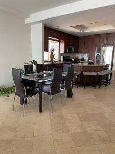 a dining room with a table and chairs and a kitchen at Playa Bonita Rosarito in Rosarito